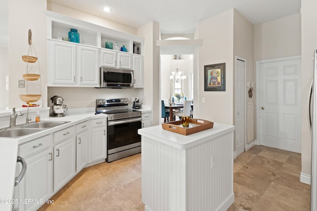 kitchen featuring open shelves, light countertops, appliances with stainless steel finishes, white cabinets, and a sink