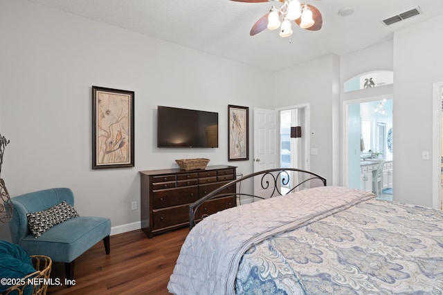 bedroom with a ceiling fan, dark wood-style floors, visible vents, baseboards, and ensuite bathroom