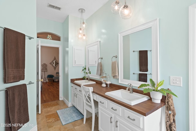 bathroom with a sink, visible vents, and double vanity