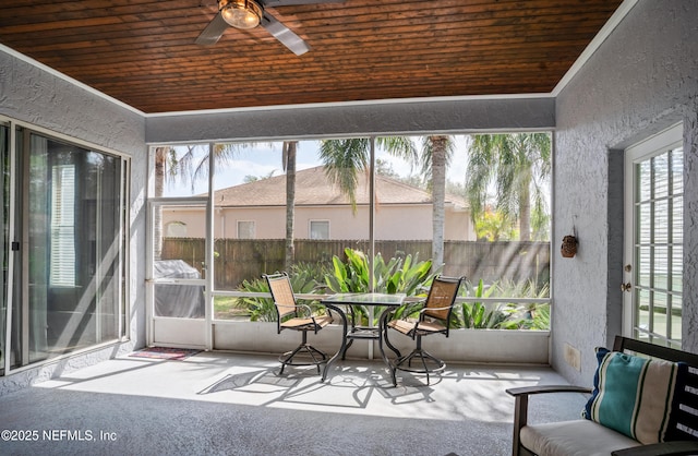 unfurnished sunroom featuring wood ceiling and ceiling fan