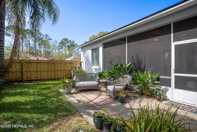 view of patio featuring fence and a sunroom