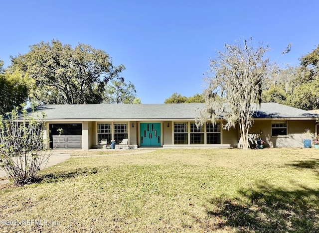 view of front of property featuring a garage, concrete driveway, and a front lawn