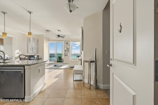 kitchen with light stone counters, light tile patterned floors, a ceiling fan, a sink, and dishwasher