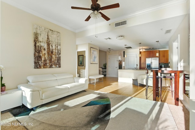 living area featuring visible vents, crown molding, and ceiling fan