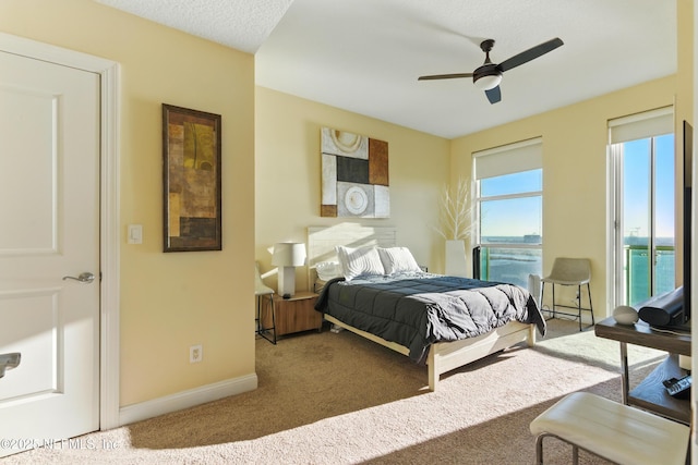 carpeted bedroom featuring a ceiling fan and baseboards