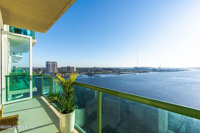 balcony with a water view and a view of city