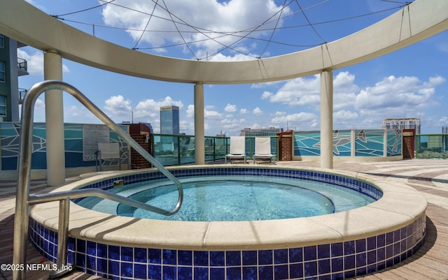 view of pool featuring a city view and a hot tub