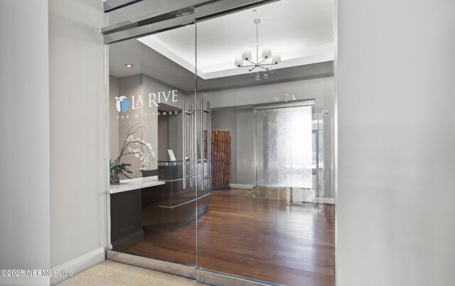 bathroom with baseboards, an inviting chandelier, and wood finished floors
