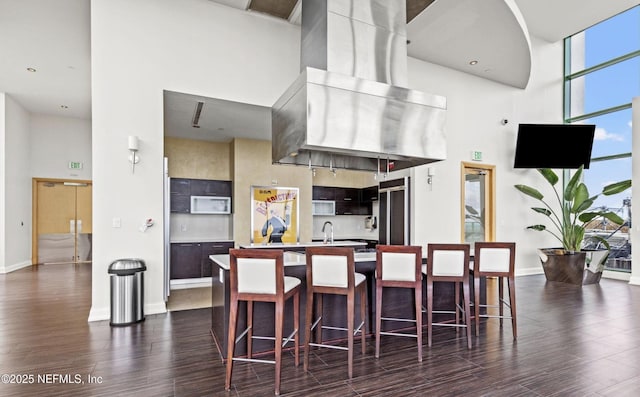 kitchen featuring dark wood finished floors, light countertops, a high ceiling, and baseboards