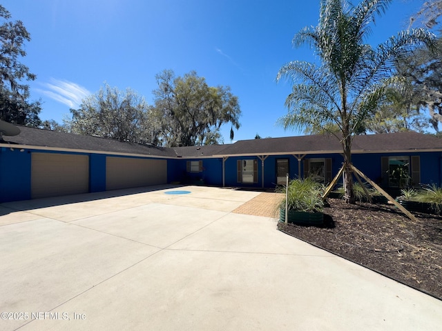 ranch-style home featuring concrete driveway and a garage