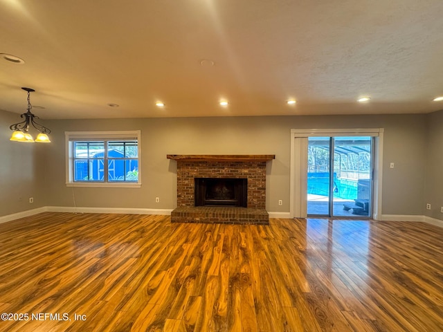 unfurnished living room with plenty of natural light, recessed lighting, baseboards, and wood finished floors