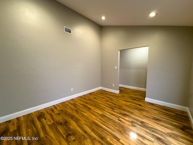 empty room featuring visible vents, recessed lighting, baseboards, and wood finished floors