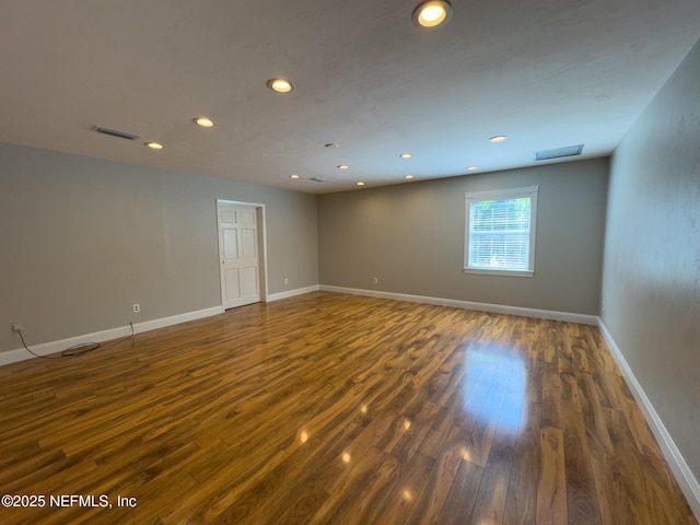 spare room featuring visible vents, recessed lighting, baseboards, and wood finished floors