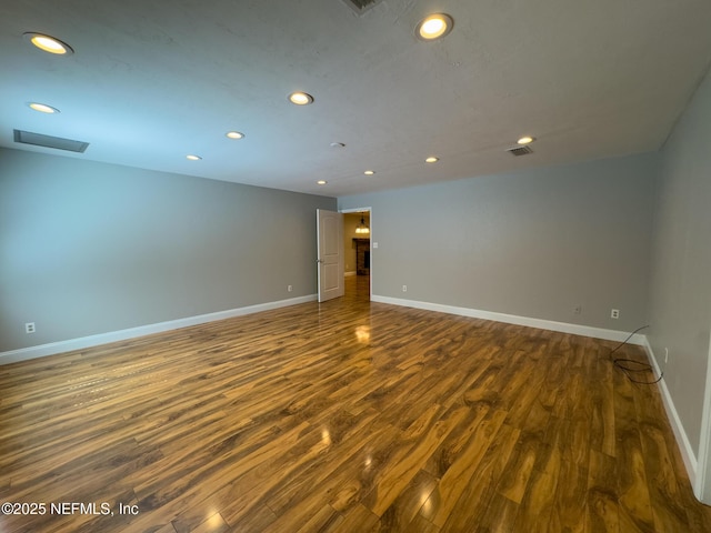 empty room featuring recessed lighting, dark wood-style floors, and baseboards