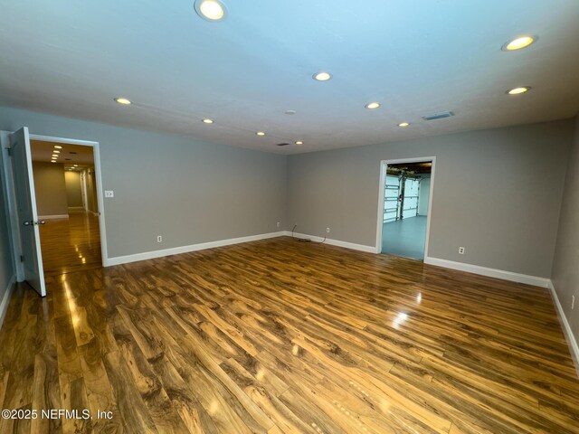 spare room with visible vents, recessed lighting, dark wood-type flooring, and baseboards