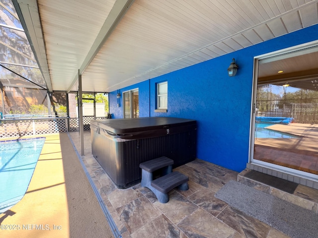 view of patio featuring glass enclosure, fence, a swimming pool, and a hot tub