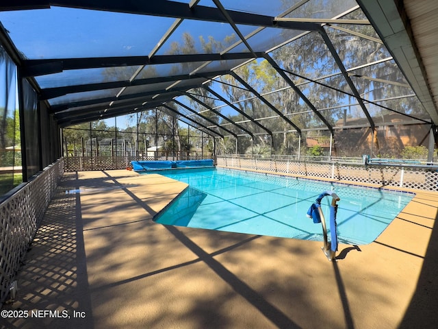 pool featuring glass enclosure and a patio