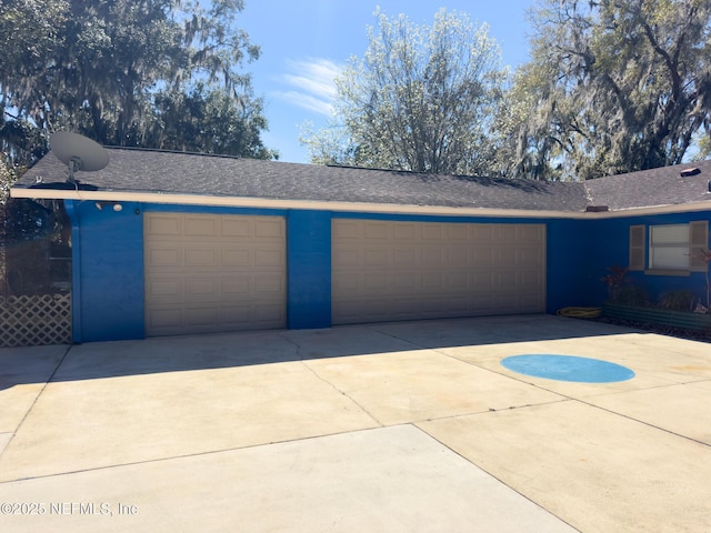 garage featuring concrete driveway