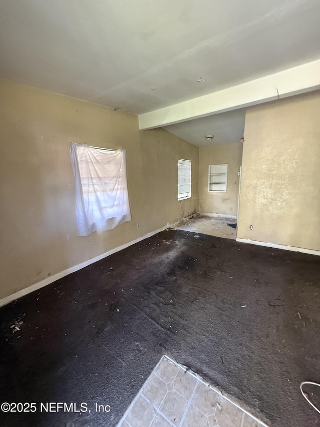 unfurnished room featuring baseboards