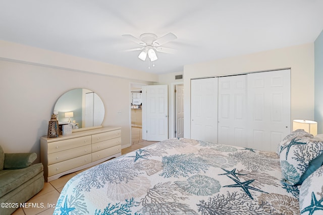 bedroom with a closet, visible vents, ceiling fan, and light tile patterned flooring