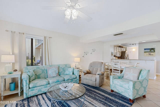 living area featuring light tile patterned flooring, visible vents, baseboards, and a ceiling fan