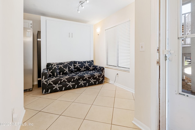 sitting room with tile patterned floors, baseboards, and track lighting