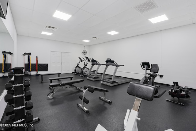 exercise room with visible vents, baseboards, and a drop ceiling