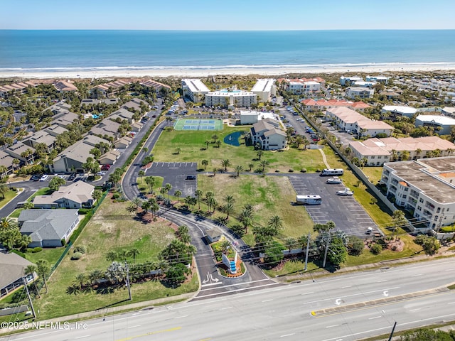 drone / aerial view featuring a view of the beach, a water view, and a residential view