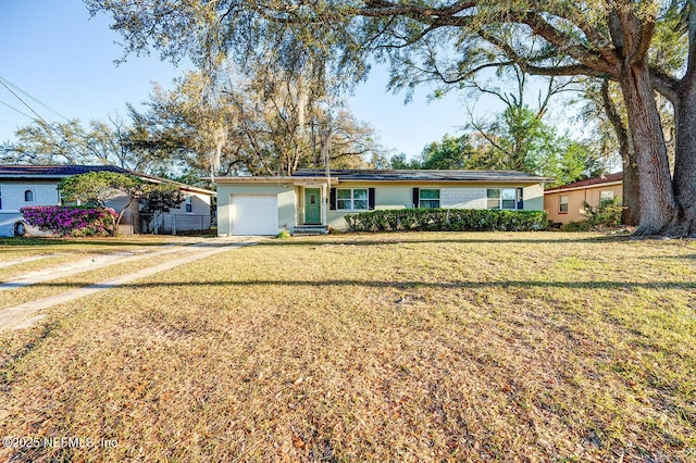 ranch-style house featuring a front lawn, an attached garage, and driveway