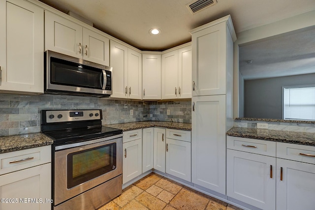 kitchen with stone tile floors, tasteful backsplash, visible vents, and stainless steel appliances