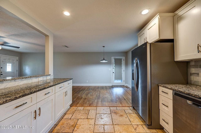 kitchen featuring stone tile floors, recessed lighting, appliances with stainless steel finishes, and baseboards