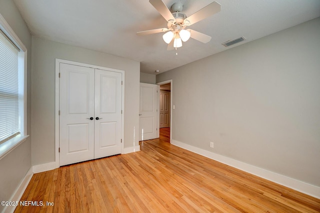 unfurnished bedroom with a closet, visible vents, light wood-style flooring, and baseboards