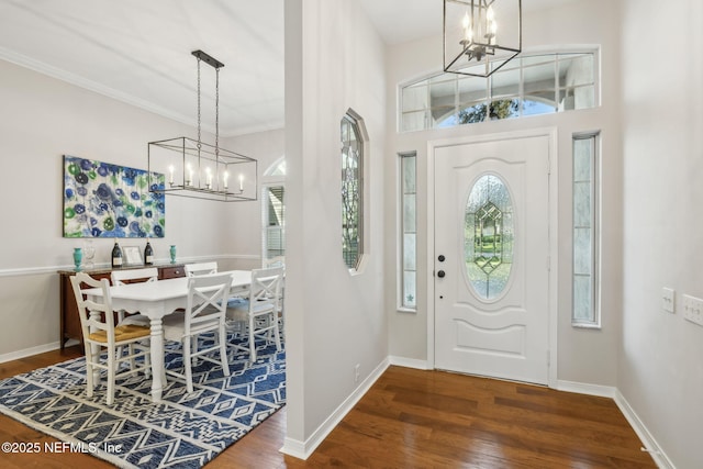 entrance foyer with a notable chandelier, wood finished floors, and baseboards