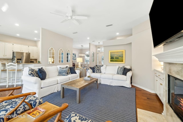 living area with light wood-style flooring, recessed lighting, a fireplace, and visible vents