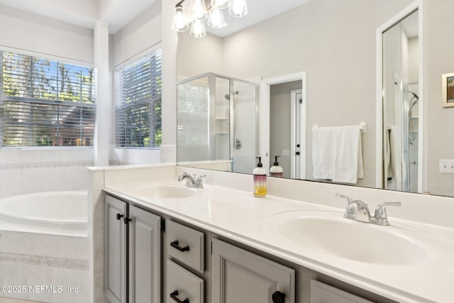 bathroom featuring a garden tub, double vanity, a stall shower, and a sink