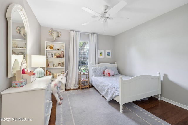 bedroom with ceiling fan, baseboards, and wood finished floors