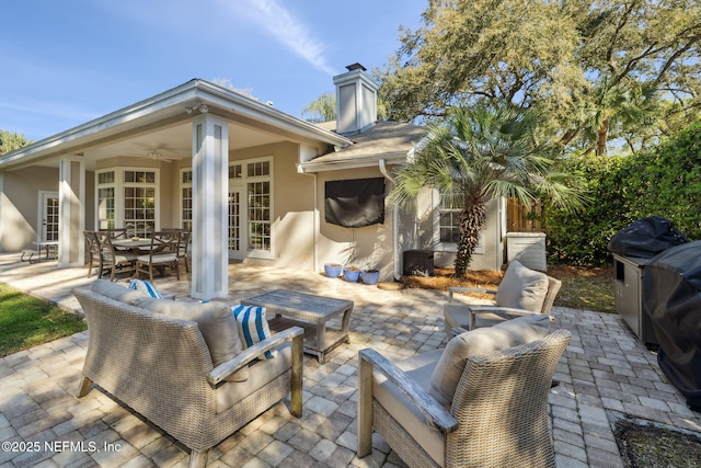 view of patio featuring outdoor dining area, a ceiling fan, and french doors