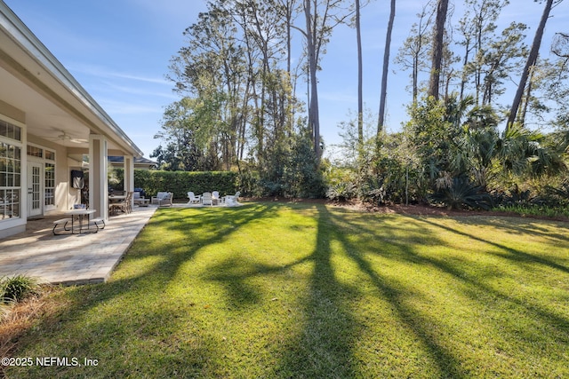 view of yard with a patio area, french doors, and ceiling fan