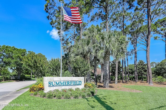 community / neighborhood sign featuring a yard