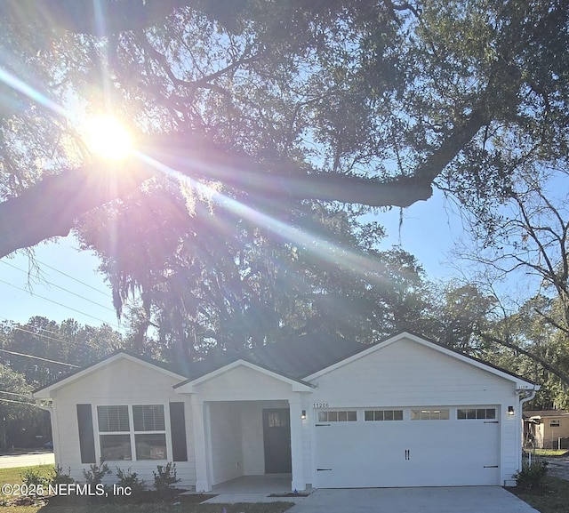 ranch-style house with concrete driveway and an attached garage