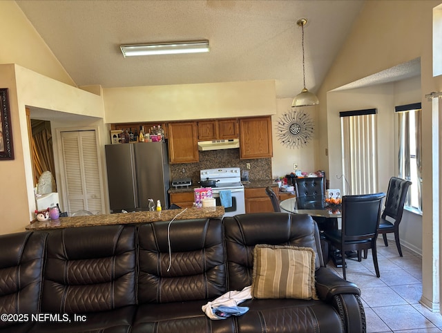 living area with lofted ceiling and light tile patterned floors