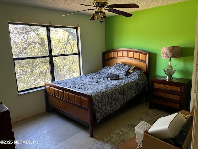 bedroom featuring ceiling fan, a textured ceiling, and baseboards