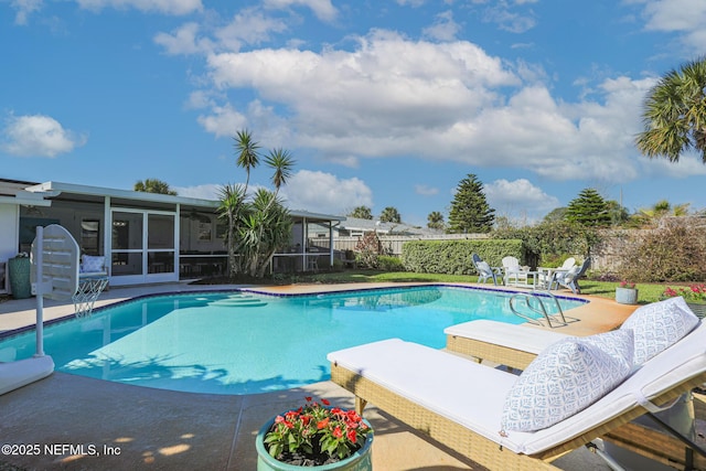 view of swimming pool with a patio area, a fenced in pool, a fenced backyard, and a sunroom