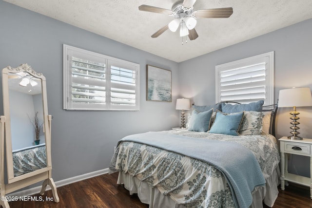 bedroom featuring ceiling fan, wood finished floors, baseboards, and a textured ceiling