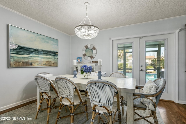 dining area featuring crown molding, french doors, wood finished floors, a notable chandelier, and a textured ceiling