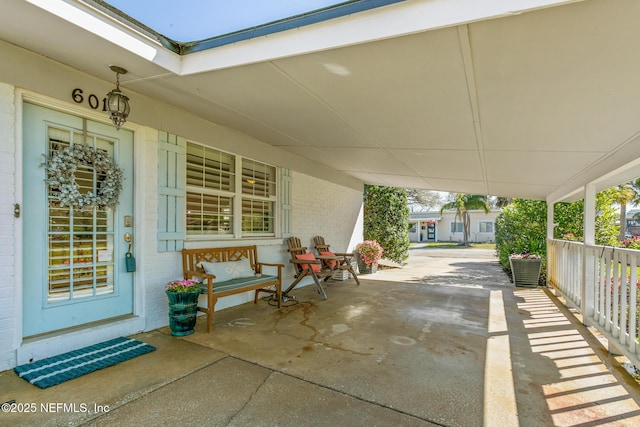 view of patio featuring an attached carport and a porch