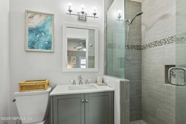 bathroom featuring vanity, toilet, ceiling fan, and a shower stall