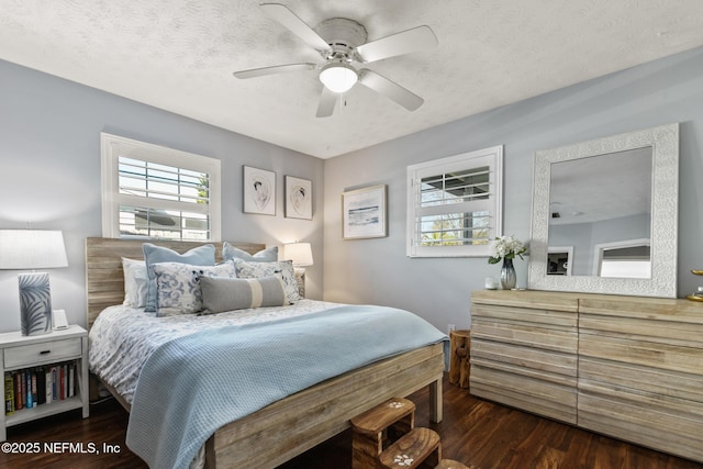 bedroom with a textured ceiling, wood finished floors, and a ceiling fan