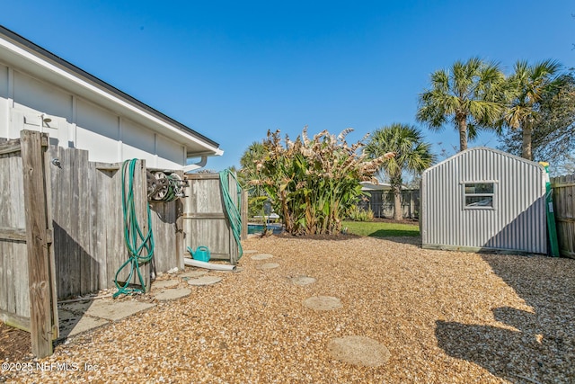 view of yard featuring a fenced backyard, a storage shed, and an outdoor structure