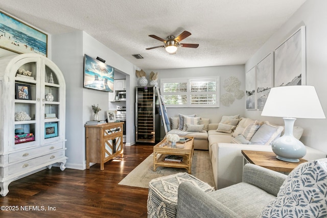 living room with visible vents, a textured ceiling, ceiling fan, and dark wood-style flooring